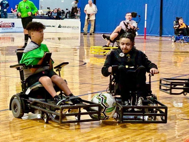 Two young men with Duchenne Muscular Dystrophy playing power soccer