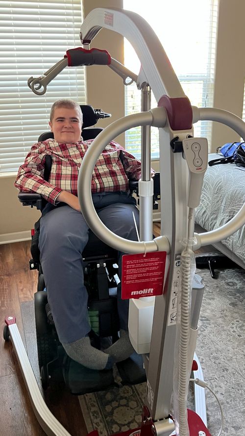 Molift assistive lift device being used by a young male with Duchenne Muscular Dystrophy