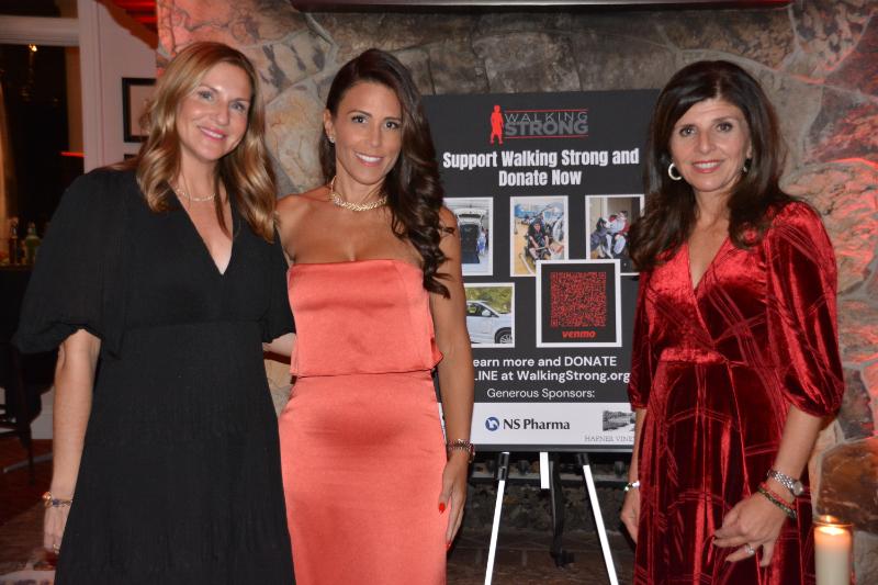 Valerie Pappas Llauro and two other women posed in front and the fundraising event sign at A Night of Cocktails & Conversation